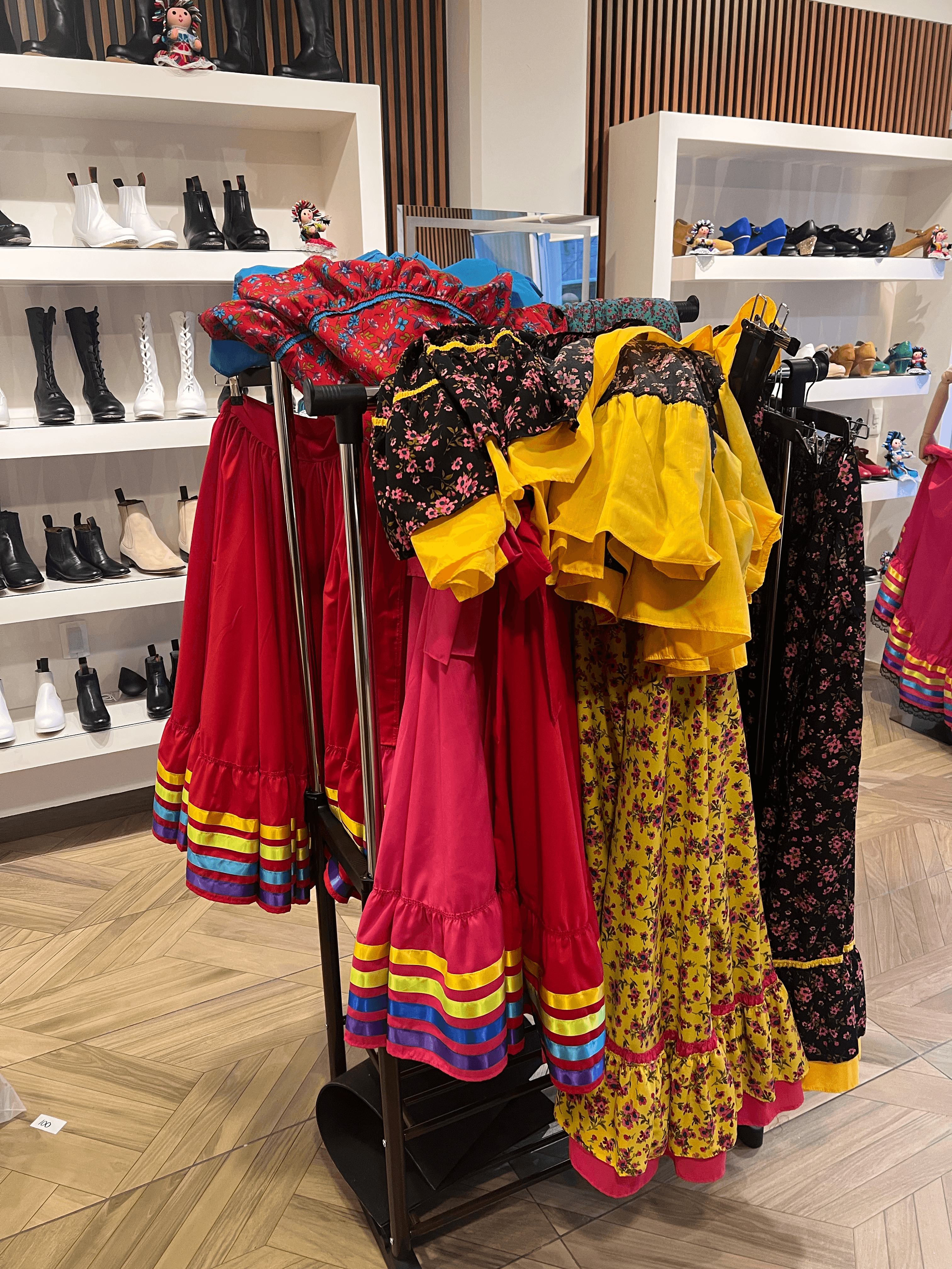 Garment rack of folklórico dresses in vibrant colors